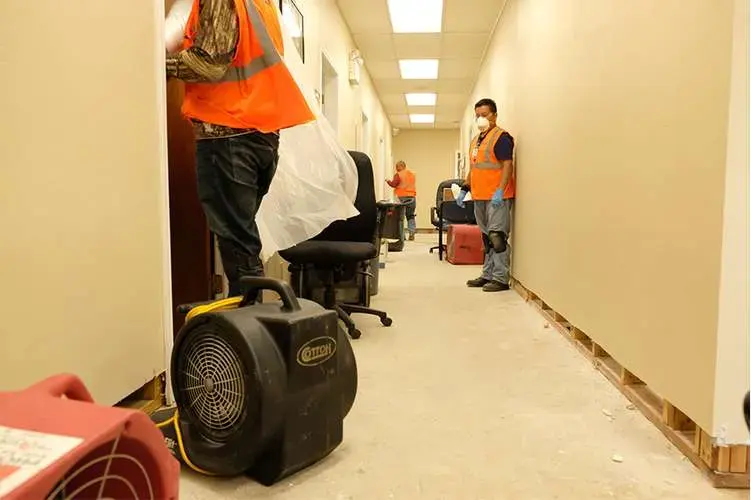 Air movers drying a commercial hallway after a water loss
