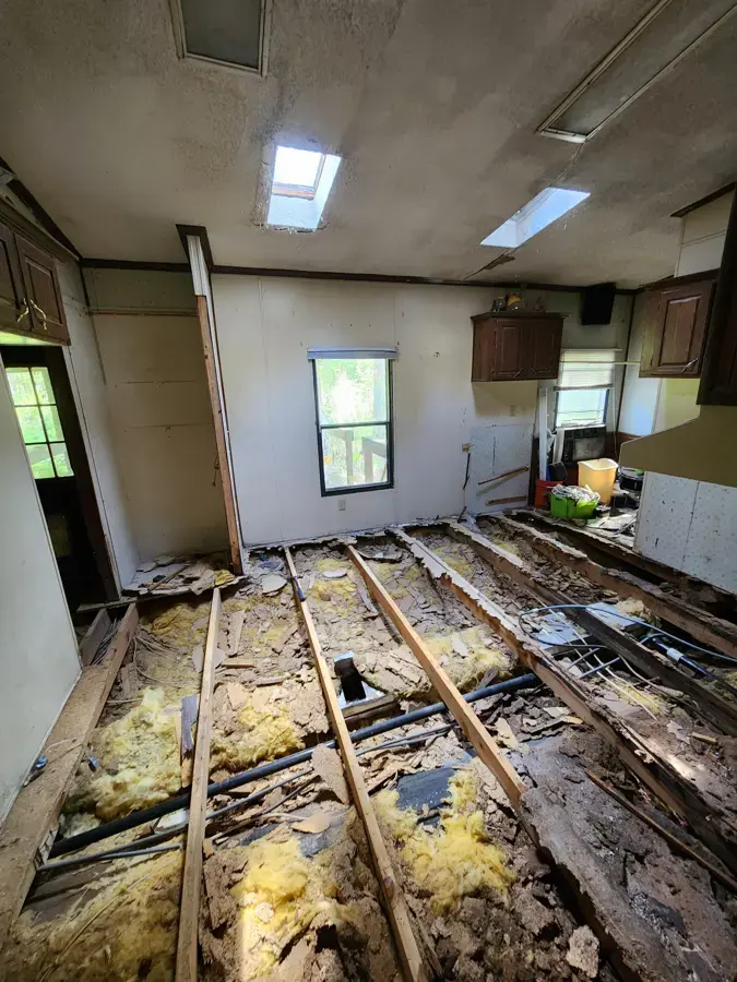 Manufactured home floor opened to wet joists and insulation after a leak